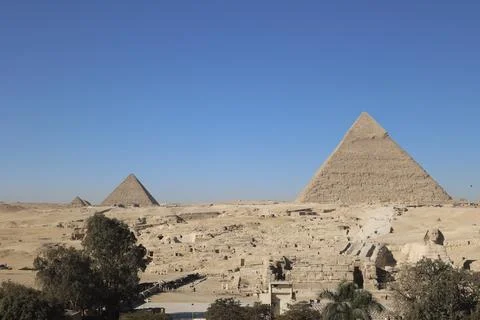 Giza pyramid complex with sand, sphinx and two smaller pyramids Stock Photos