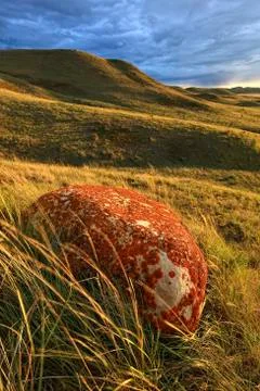 A glacial erratic and storm clouds at sunset over the Frenchman River valley, Stock Photos