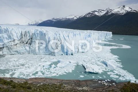 Glacial ice from the perito moreno glacier calving into the lake of lago arge Stock Photos
