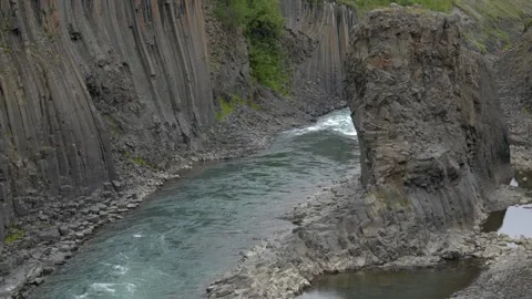 Glacial River Flowing Through Basalt Column Formations of Stuðlagil Canyon in Stock Footage 339877327