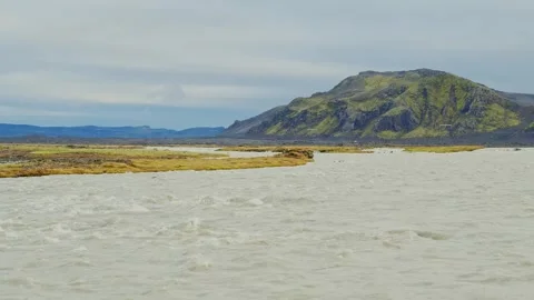 Glacial River Flows Through a Volcanic Landscape in the Highlands of Iceland Stock Footage 320511439
