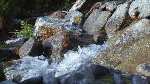 Glacial water flows from the mountains through the rocks 動画素材 103968627