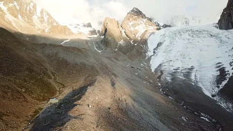 Glacier among rocks. Clouds are visible in the blue sky. Stock-Footage 95104399