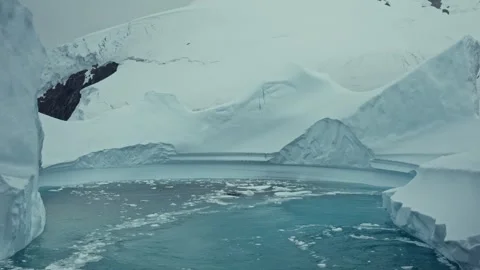 Glacier channel filled with floating ice stretches between towering ice walls Vídeos de archivo 339131337