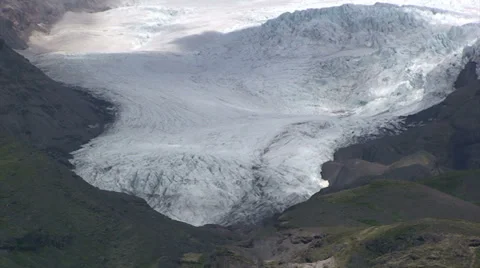 Glacier descends down the valley as clouds cast shadow Stock Footage 37779236