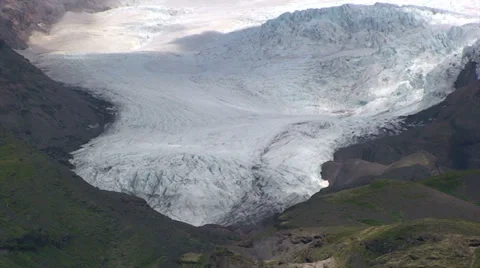 Glacier descends down the valley as clouds cast shadow Stock Footage 37779278