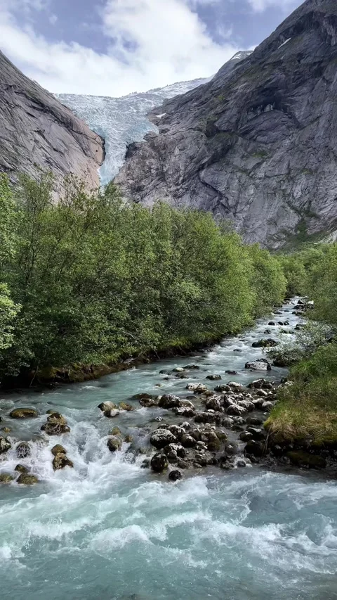 The glacier flows down from the mountains briksdal Stock Footage 337365068