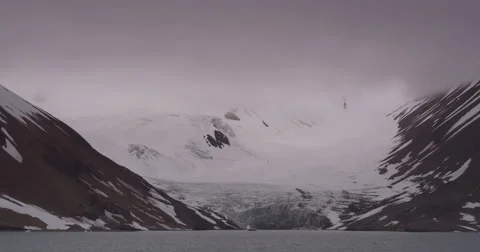 Glacier Flows out of Cloudy Mountains into Ocean Video stock 61515880