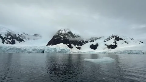 Glacier Front Beneath Cloud Covered Peaks in Paradise Bay, Antarctica Stock Footage 339093783