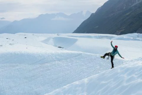 Glacier guide dancing in crampons on one leg. Stock Photos