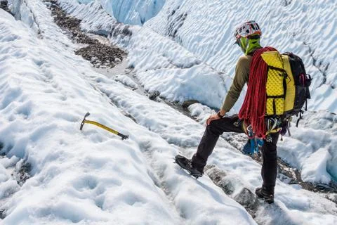 Glacier guide evaluating terrain while trekking across the Matanuska Glacier  Stock Photos