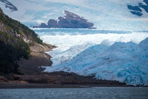 The glacier slides over the surface of the mountain and the beach. Shevelev. Stock Photos
