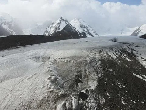 Glacier surface depression and distant snowy peaks Stock Photos