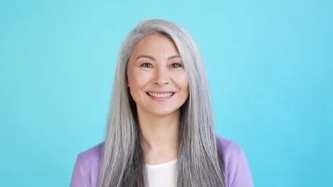 Glad lady portrait look in camera smiling isolated on blue color background 動画素材 165348822