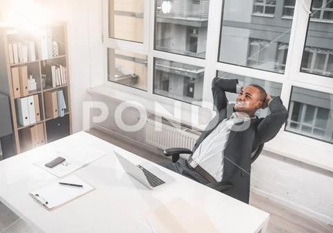 Glad respectable man resting in cabinet and laughing Stock Photos