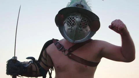 Gladiator or Roman Warrior in Helmet and Armor Posing with Sword Low Angle Stock Footage 321746486
