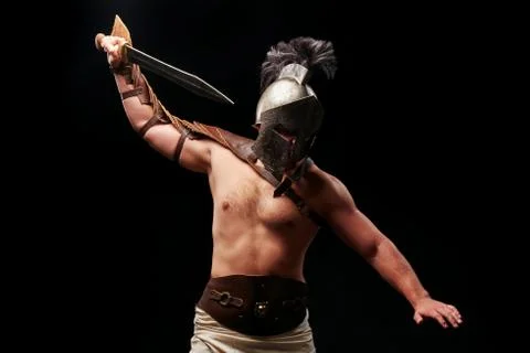 Gladiator with sword and armor on a black background Stock Photos