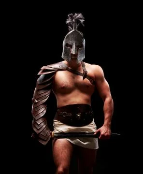 Gladiator with sword and armor on a black background Stock Photos