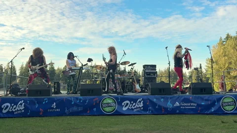 A glam rock band performs on a stage decorated with banners under a blunevada-32 Stock-Footage 343812649