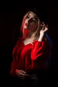 Glamorous blonde model with red lips posing in the shadow with blue and red l Foto stock