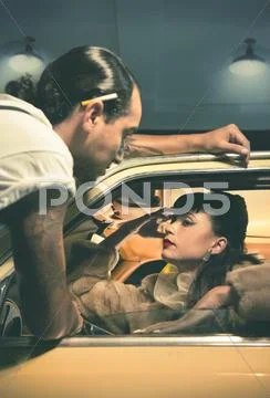 Glamorous couple talking in vintage car Stock Photos