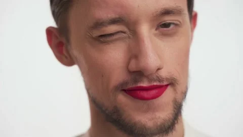 Glamorous man with beard, painted lips smiles, winks with brown eyes, flirts Video stock 147571650