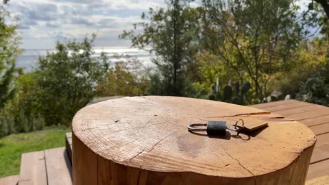 Glamping keys resting on a rustic wooden table on a cozy veranda Stock Footage 304879478