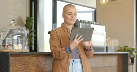 Glancing at tablet, female cafe worker tilting and tapping screen, confirming Stock Footage 341932000