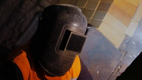 Glare of fire is reflected, flickers and glowes in protective mask of worker Stock Footage 121644867