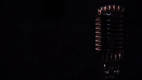 Glare microphone in dark isolated space close up. Spotlights shine on retro mic. Stock Footage 118528649