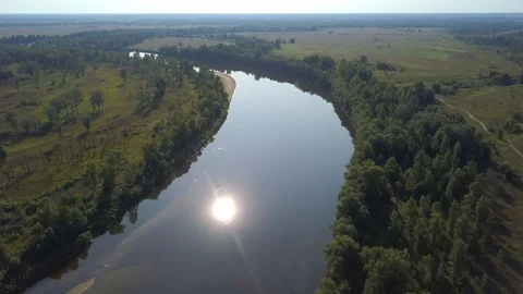 Glare of the sun reflected in a beautiful river. Aerial view. Stock Footage 117415488