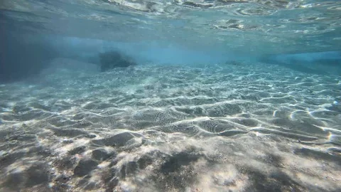 Glare of the sun on a sandy bottom in the surf zone. Sunrays on seabed. 库存影片 126502885