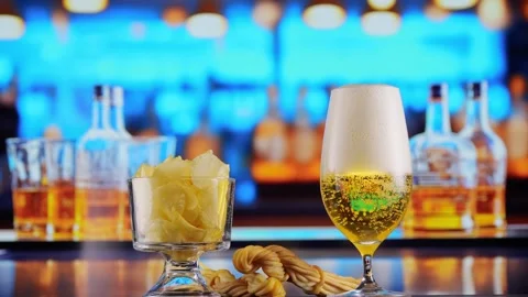 Glas of Beer with Snacks and Chips in alcoholic bar, forming bubbles and a Stock Footage 258766959
