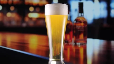 Glas of Beer with Snacks and Chips in alcoholic bar, forming bubbles and a Stock Footage 259821408
