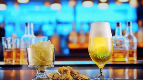 Glas of Beer with Snacks and Chips in alcoholic bar, forming bubbles and a Stock Footage 265257031