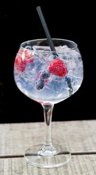 Glas Gin tonic with raspberry and blueberry Stock Photos