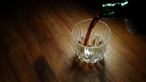 Glass of alcohol on the table in the darkness. Stock Footage 274451377