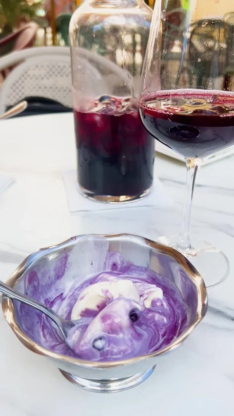 A glass and a pitcher of cold red sangria with ice cubes. Видео 339083971