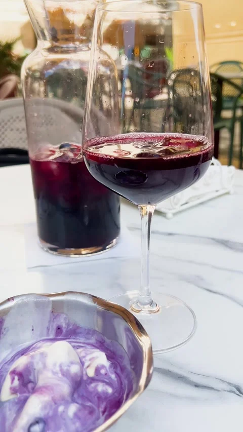 A glass and a pitcher of cold red sangria with ice cubes. Video stock 339084297