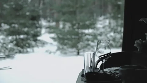 Glass and wine glasses on the table, winter window view on the background. The Video stock 248380288