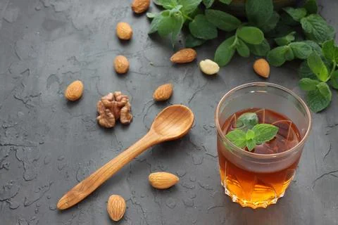 A glass of aromatic tea with a mint leaf on a stone slab. Fotos Stock