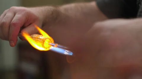 Glass artwork being heated in flame with foreground elements Stock Footage 235879346