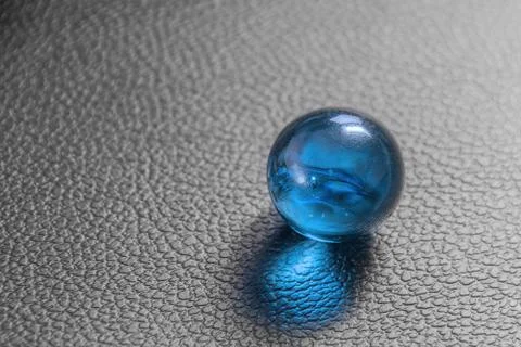 Glass ball on black leather background Stock Photos