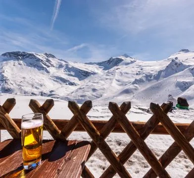 Glass of beer or lager on table in the  ski resort. Stock Photos