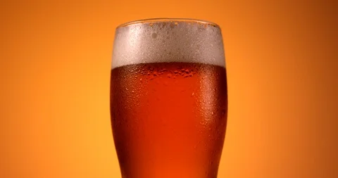 Glass of beer rotating in slow motion. Close up view, shot on RED 6K camera Stock Footage 107523913