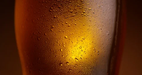 Glass of beer rotating in slow motion. Extreme close up view, shot on RED 6K Stock Footage 107528115