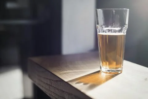 Glass of beer on wooden table at bar. Stock Photos
