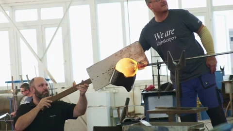 Glass blower shaping a bubble of melted glass on a rod. Glass manufacturing Stock Footage 164175518