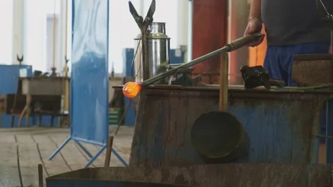 Glass blower shaping a bubble of melted glass on a rod. Glass manufacturing Stock Footage 170402419