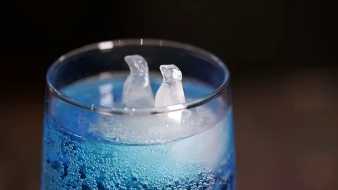 A glass of blue cold drink, floating polar bear-shaped ice Stock Footage 71024887